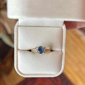 Sapphire ring surrounded by 8 small diamonds (four on each side).  Gold setting.